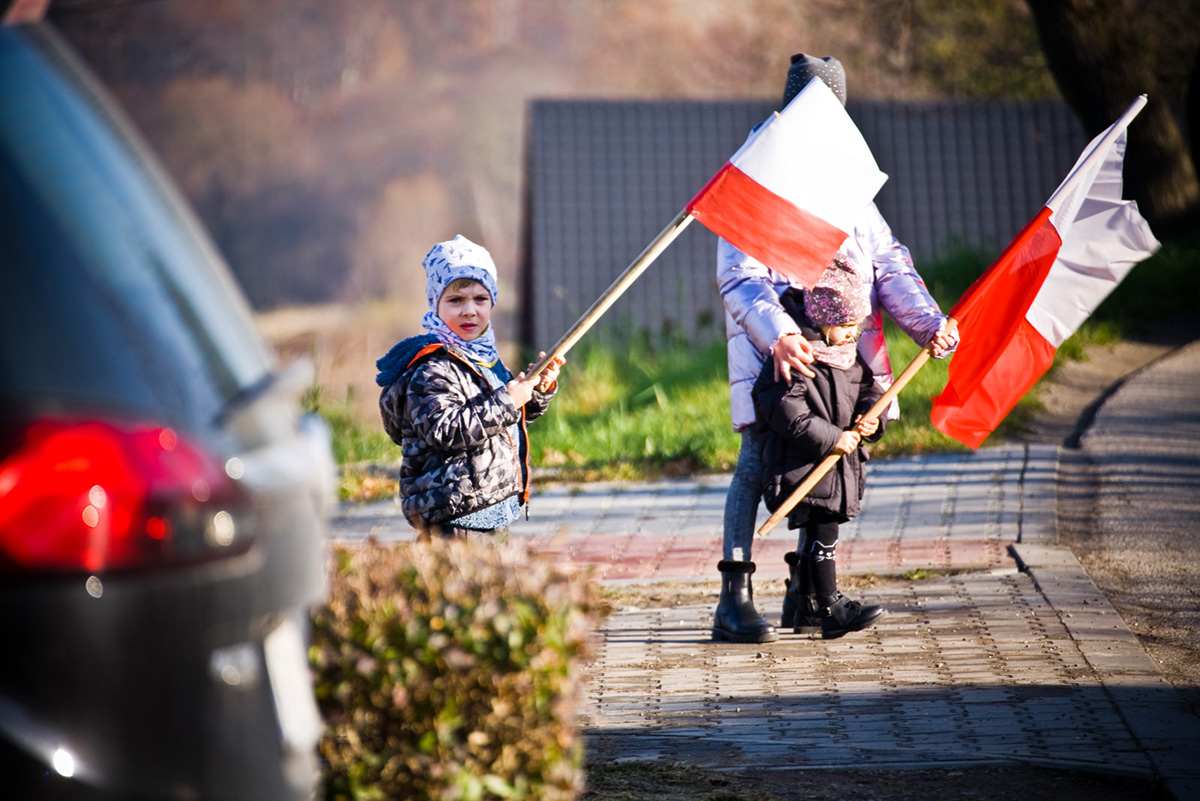 dzieci z flagami Polski na trasie Biegu niepodległości 2021