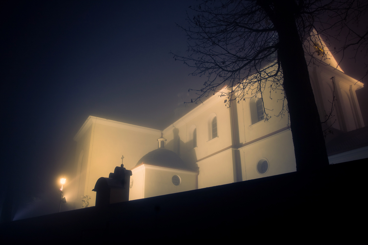 oświetlony kościół w Mogilanach nocą listopadową we mgle
